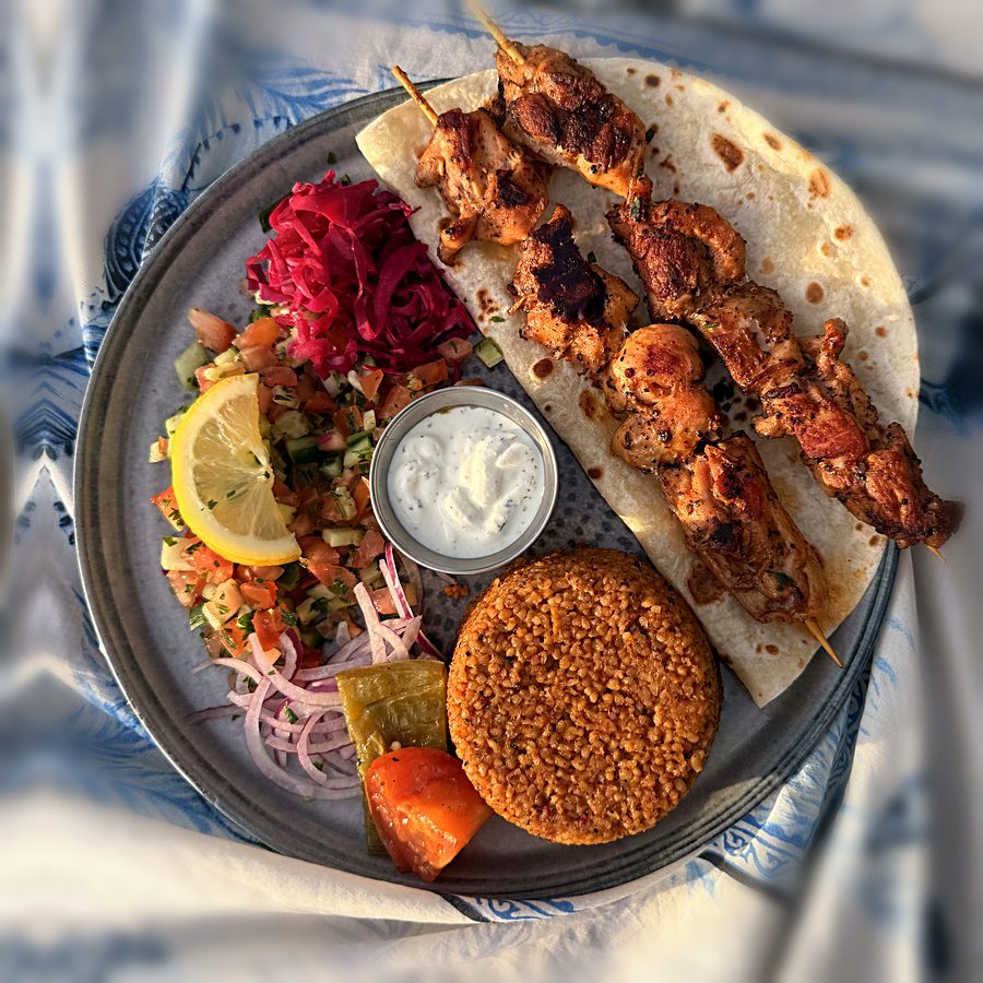 L'assiette de brochettes de poulet, blé aux poivrons, salade bergère et sauce maison